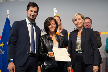 Cécile Neven et Adrien Dolimont, durant la cérémonie des mérites, remettent un prix à la mère de Jodie Devos.