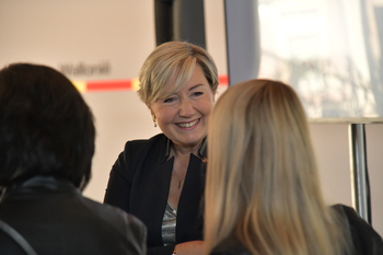 Cécile Neven, très souriante, entamme une discussion avec plusieurs personnes lors des fêtes de Wallonie.