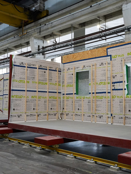 Photo prise dans le hangar de Marchienne-au-Pont montrant un module en construction, avec des panneaux isolants visibles sur la structure du box.